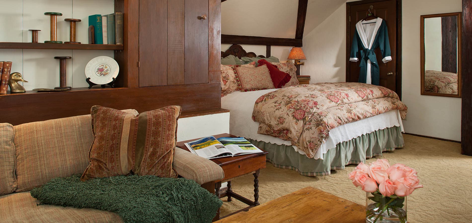 Cozy bedroom with floral bedding, a plush couch, and warm wood accents.