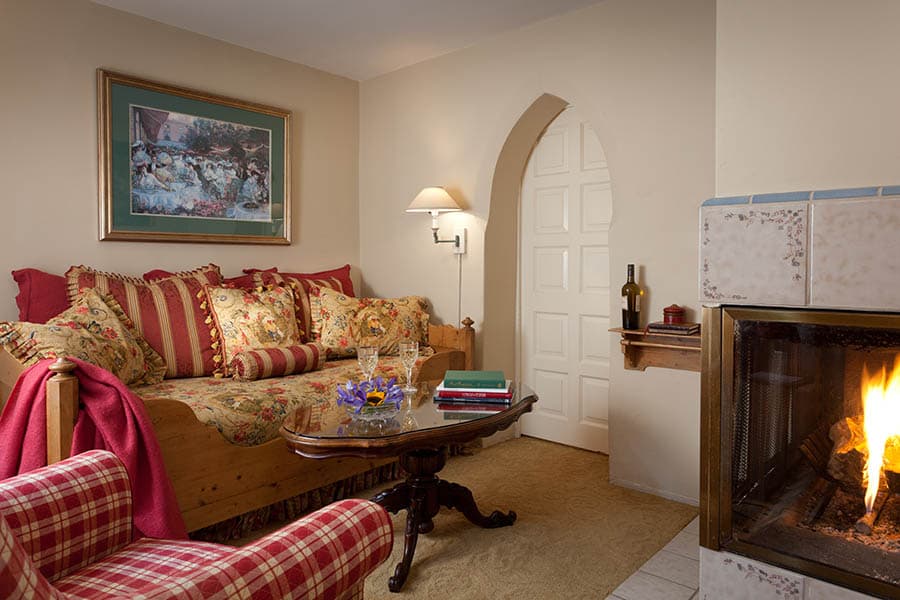 Cozy living room featuring a fireplace, a patterned sofa, and a small coffee table.
