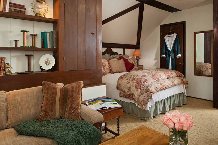 dovecote room with bed, sitting area and fireplace