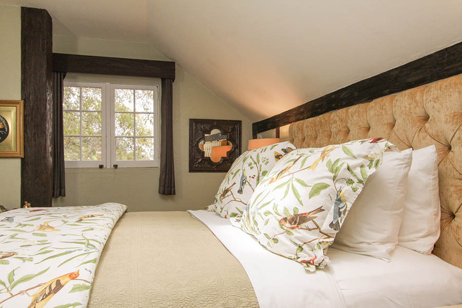 rookery room with fireplace and bird motif on bed and chairs