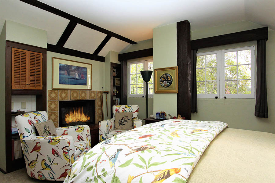 rookery room with fireplace and bird motif on bed and chairs